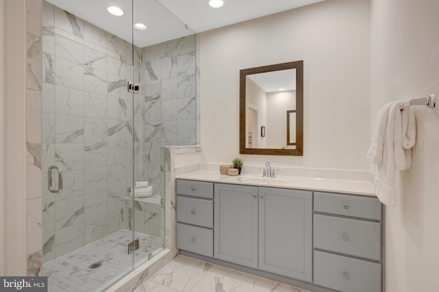 full bathroom featuring marble finish floor, a shower stall, vanity, and recessed lighting