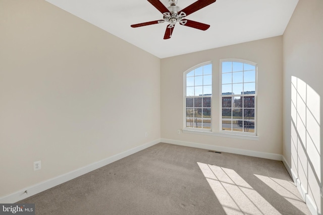 empty room featuring light carpet, baseboards, visible vents, and a ceiling fan