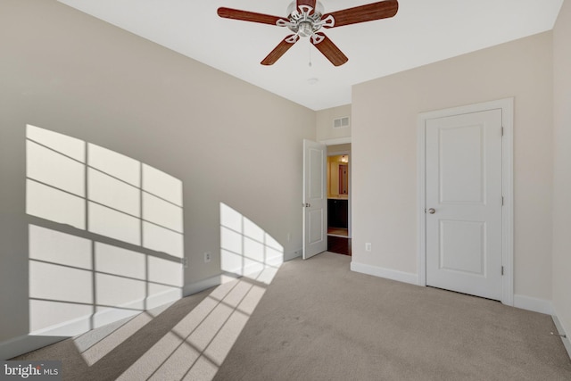 empty room featuring baseboards, visible vents, ceiling fan, and light colored carpet