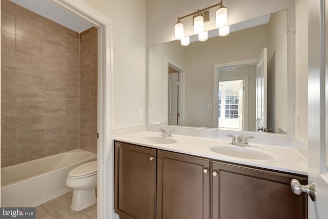 full bathroom with toilet, tile patterned flooring, double vanity, and a sink