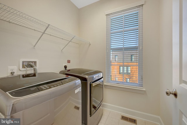 laundry room featuring light tile patterned floors, laundry area, visible vents, baseboards, and independent washer and dryer