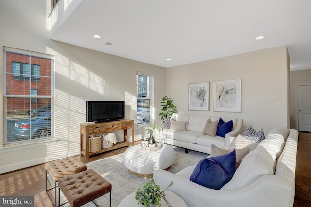 living area featuring baseboards, wood finished floors, visible vents, and recessed lighting