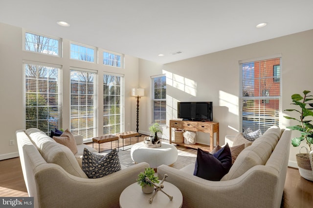 living room featuring recessed lighting, baseboards, and wood finished floors