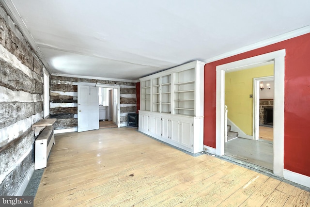 unfurnished living room with a fireplace, built in shelves, light hardwood / wood-style flooring, and ornamental molding