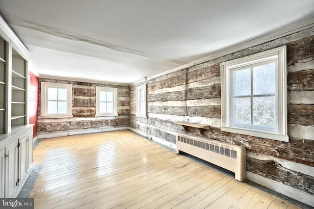 interior space with ornamental molding, radiator heating unit, and light wood-type flooring