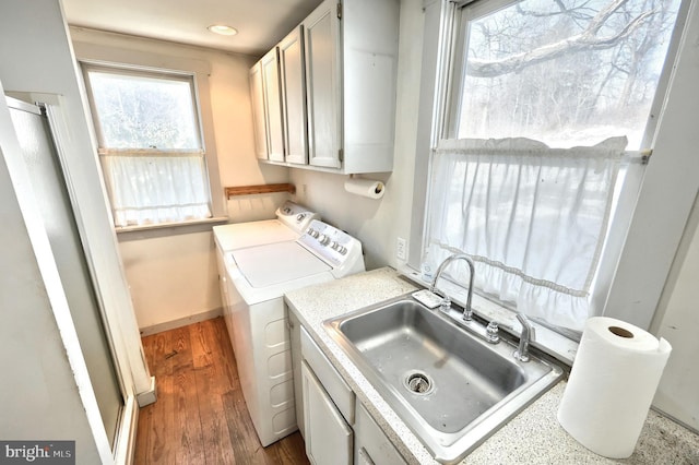 laundry room with sink, wood-type flooring, cabinets, and washing machine and clothes dryer