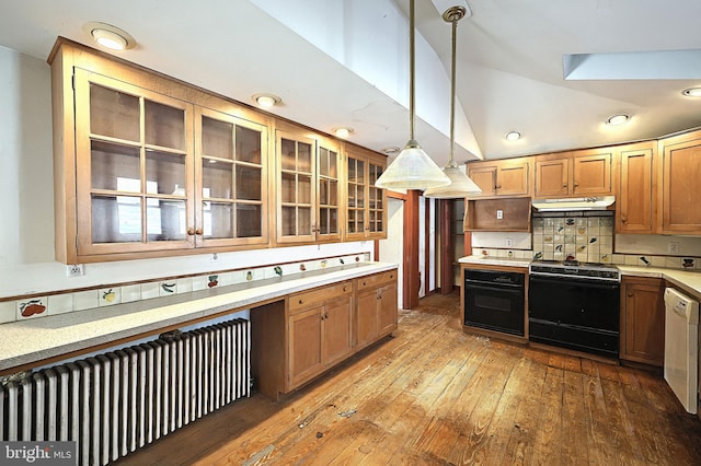 kitchen with radiator, tasteful backsplash, wood-type flooring, hanging light fixtures, and black appliances