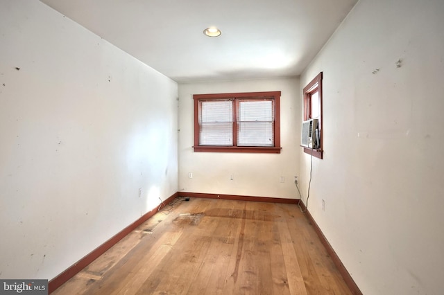 unfurnished room featuring cooling unit and hardwood / wood-style flooring