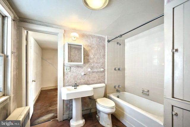 bathroom featuring toilet and tiled shower / bath combo