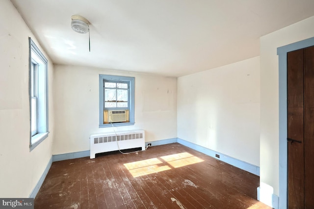 empty room with radiator, cooling unit, and dark hardwood / wood-style floors