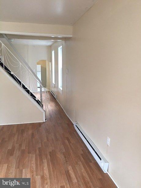 interior space featuring wood-type flooring and a baseboard heating unit