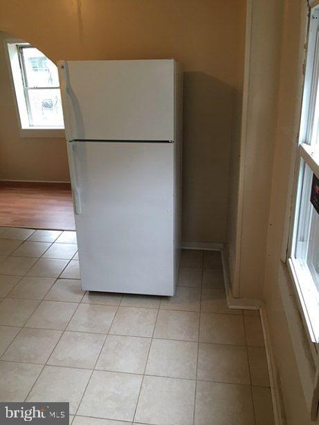 kitchen with white refrigerator and light tile patterned flooring