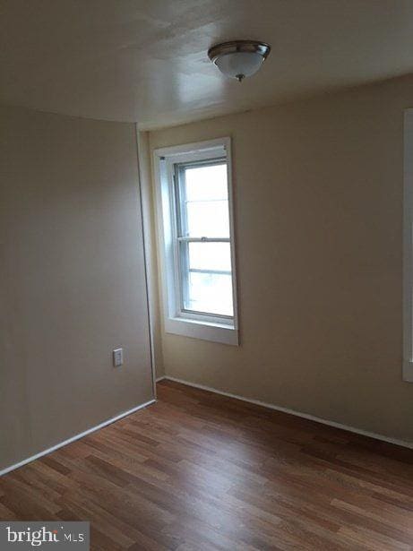 unfurnished room featuring dark wood-type flooring