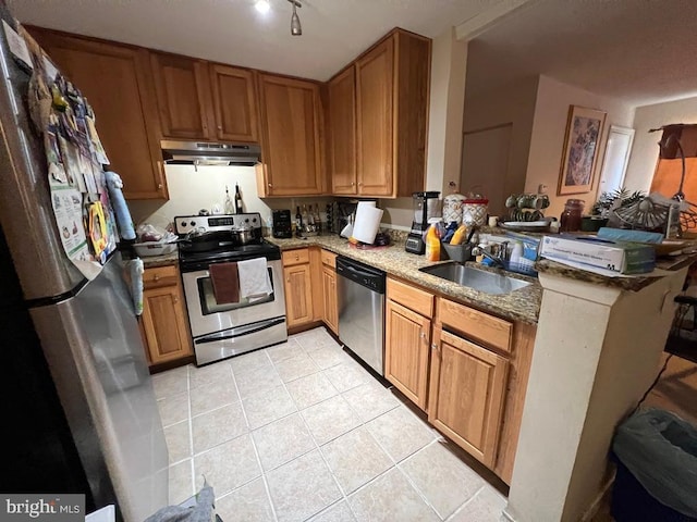 kitchen featuring stone counters, sink, light tile patterned floors, kitchen peninsula, and stainless steel appliances