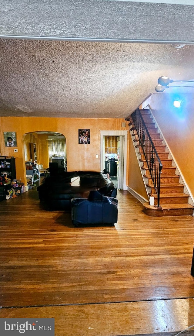 living room featuring a textured ceiling and hardwood / wood-style floors