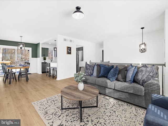 living room with sink and light hardwood / wood-style floors