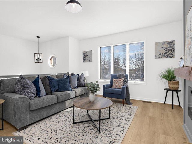 living room with a notable chandelier and light hardwood / wood-style floors