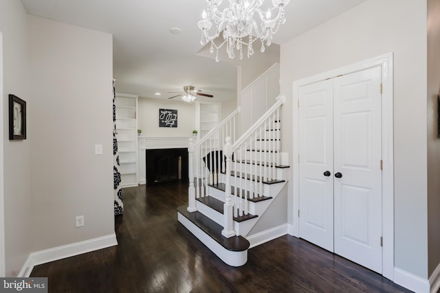 stairway with hardwood / wood-style floors, ceiling fan, and built in shelves