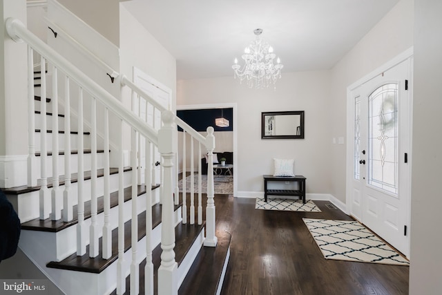 foyer entrance featuring dark wood-type flooring and a notable chandelier