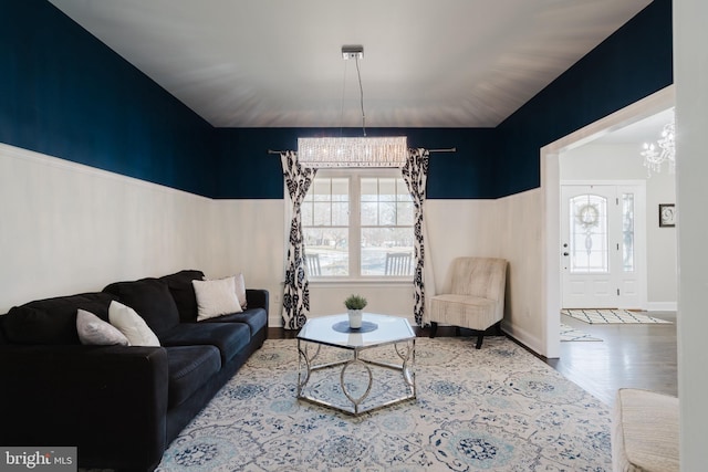 living room with wood-type flooring, a wealth of natural light, and a notable chandelier