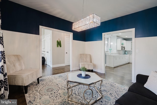 living room featuring wood-type flooring and a notable chandelier