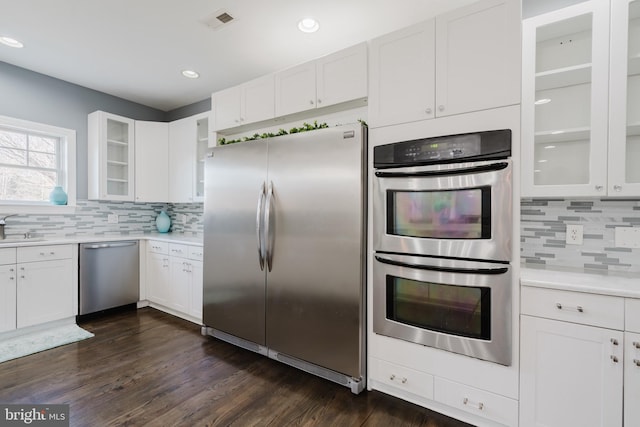 kitchen featuring sink, appliances with stainless steel finishes, white cabinetry, tasteful backsplash, and dark hardwood / wood-style flooring