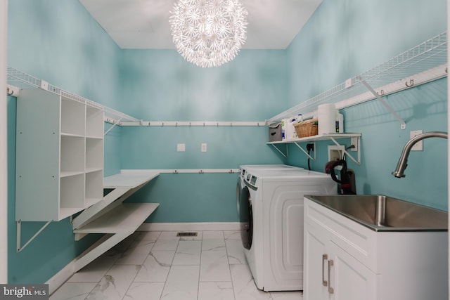 laundry area with washer and dryer, sink, and a chandelier