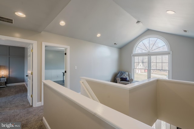 hall featuring lofted ceiling and carpet