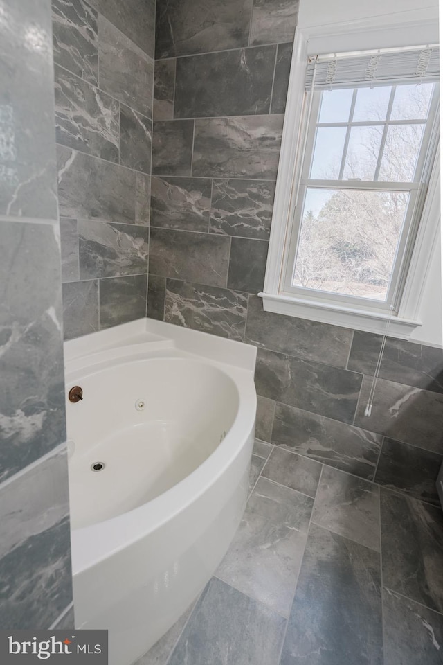 bathroom with tile walls and a bathtub