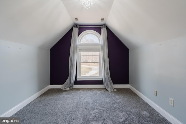 additional living space featuring an inviting chandelier, vaulted ceiling, and carpet flooring