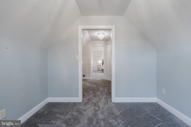 bonus room featuring vaulted ceiling and dark carpet