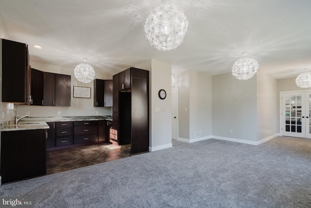 kitchen featuring dark brown cabinetry, a chandelier, and hanging light fixtures