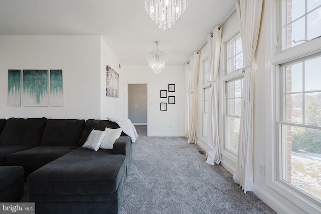 carpeted living room featuring a chandelier