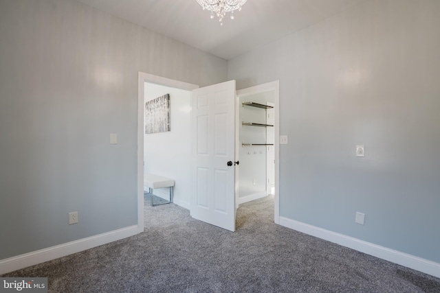 unfurnished bedroom with a notable chandelier and carpet floors