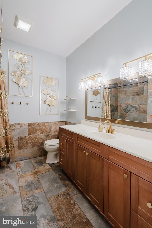 bathroom featuring tile walls, vanity, and toilet