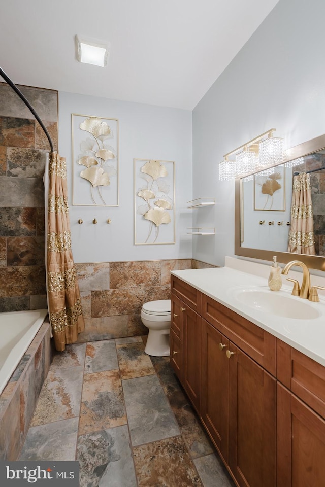 full bathroom featuring vanity, tile walls, shower / tub combo with curtain, and toilet