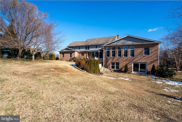 rear view of property featuring a yard