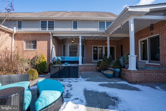 back of house featuring an outdoor living space and a patio