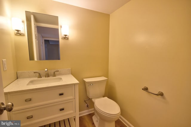 bathroom with vanity, wood-type flooring, and toilet