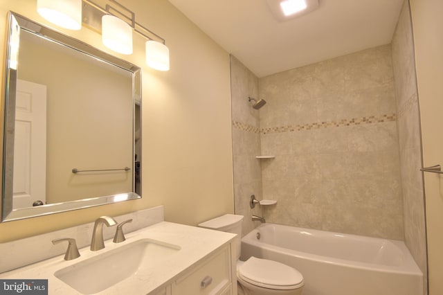 full bathroom with tiled shower / bath, vanity, and toilet