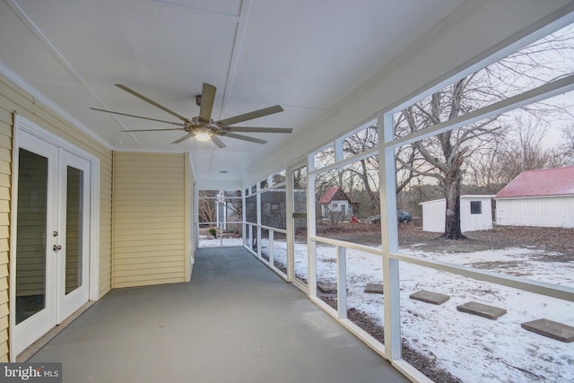 snow covered patio with ceiling fan and french doors