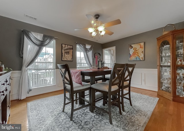 dining area with light wood-type flooring and ceiling fan