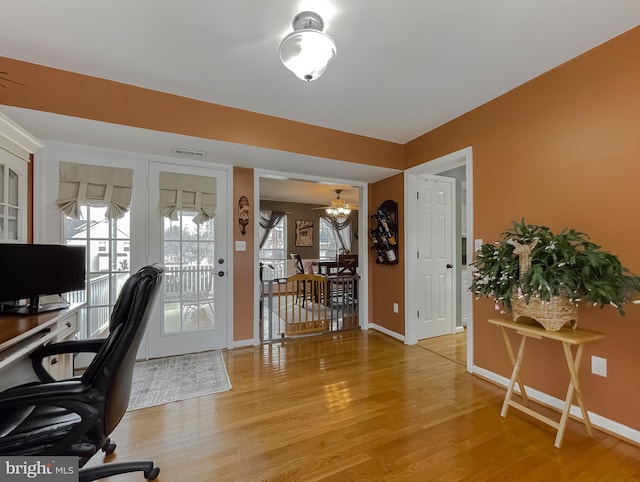 home office with hardwood / wood-style flooring and ceiling fan