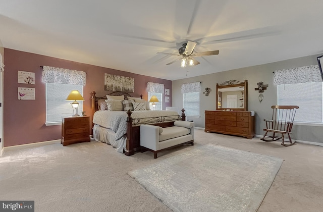 bedroom with light carpet, multiple windows, and ceiling fan