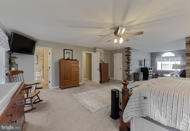 bedroom featuring light colored carpet, ceiling fan, and ensuite bathroom