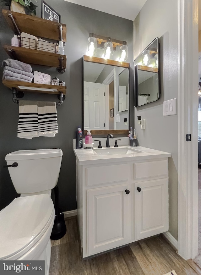 bathroom featuring hardwood / wood-style flooring, toilet, and vanity