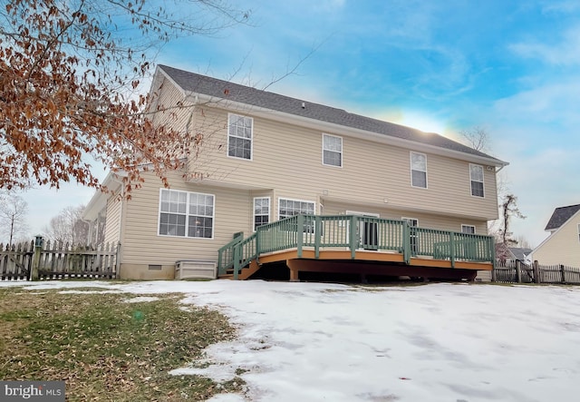 snow covered house with a wooden deck