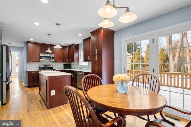 dining space with sink and light wood-type flooring