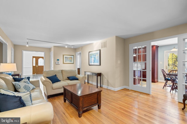 living room with rail lighting and light wood-type flooring