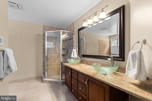 bathroom with vanity, a shower with shower door, and tile patterned flooring